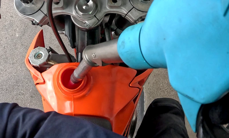 Um den Höhepunkt der Abgas-Lust zu erreichen, braucht man wohl oder übel Benzin. Der Tank eines Zweitakt-Motorrades wird an der Zapfsäule aufgefüllt.