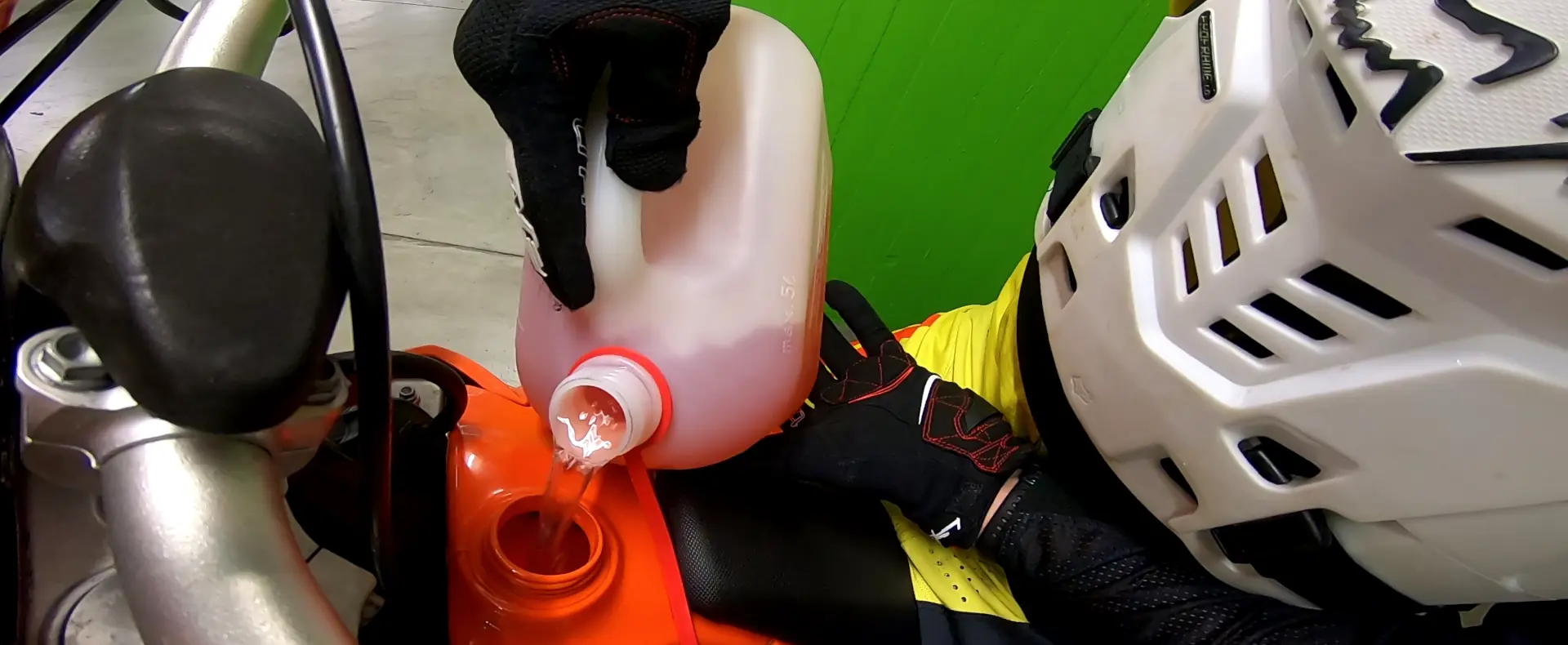 The tank of an offroad motorcycle is being filled with gasoline